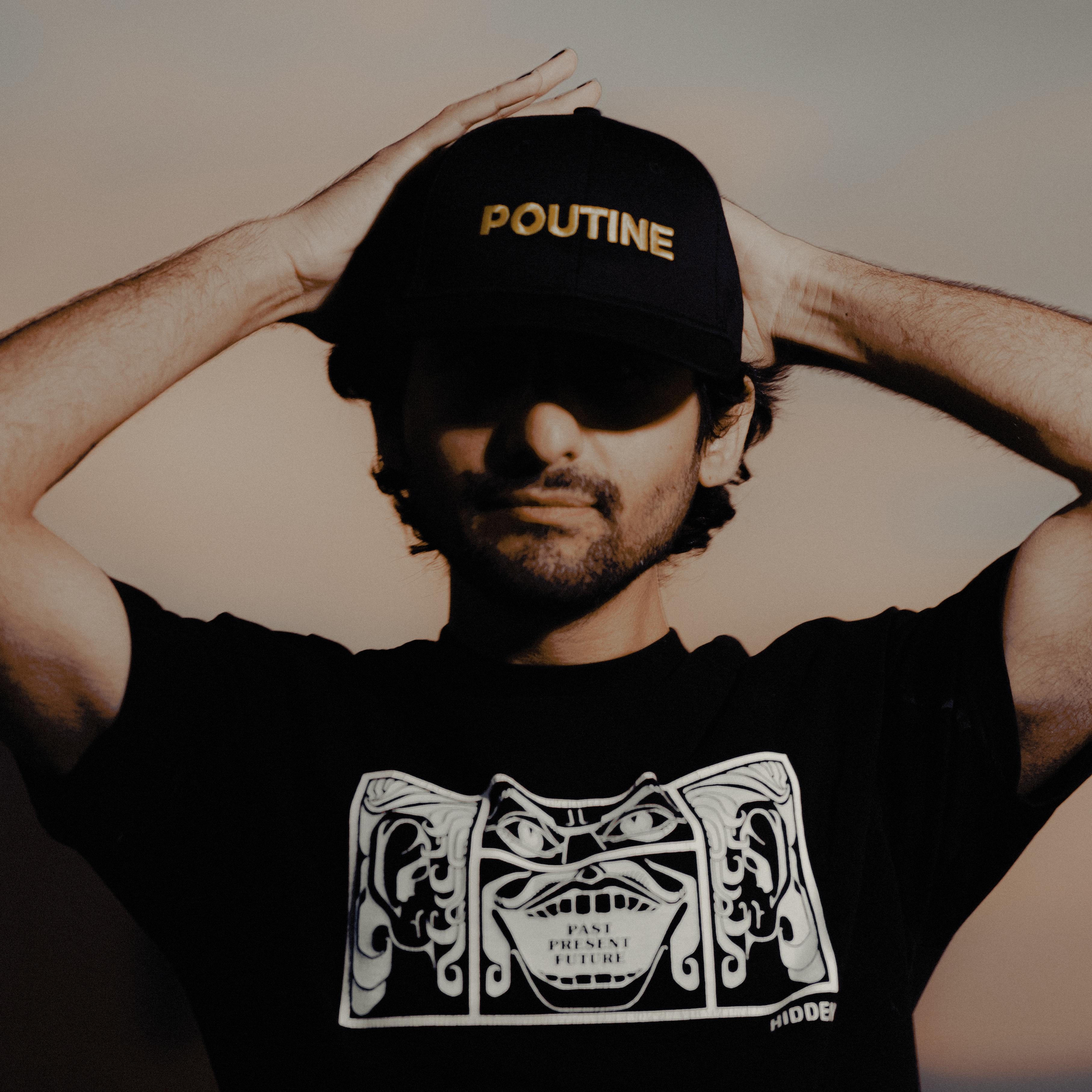 Payraw, photographed wearing a black POUTINE cap.